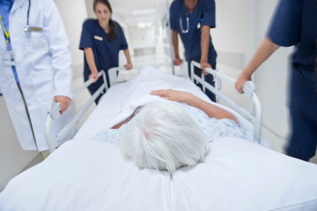 Equipo de salud trasladando a una paciente en cama dentro de un hospital